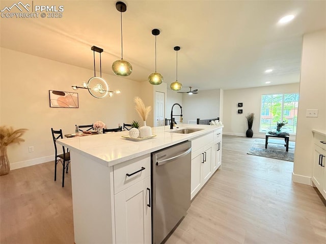 4770 Newton Dr, Colorado Springs, CO 80916 - kitchen with a sink, dishwasher, light wood-style flooring, a kitchen island with sink, and pendant lighting