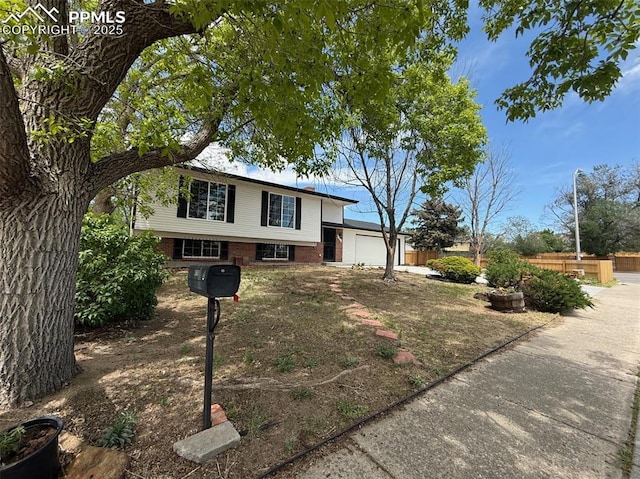 4770 Newton Dr, Colorado Springs, CO 80916 - tri-level home featuring a garage and brick siding