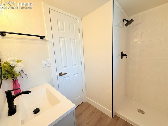 4770 Newton Dr, Colorado Springs, CO 80916 - full bathroom featuring wood finished floors, tiled shower, baseboards, vanity, and crown molding