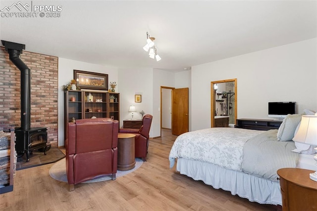 802 Red Eagle Ct, Woodland Park, CO 80863 - bedroom featuring a wood stove and light wood-style flooring