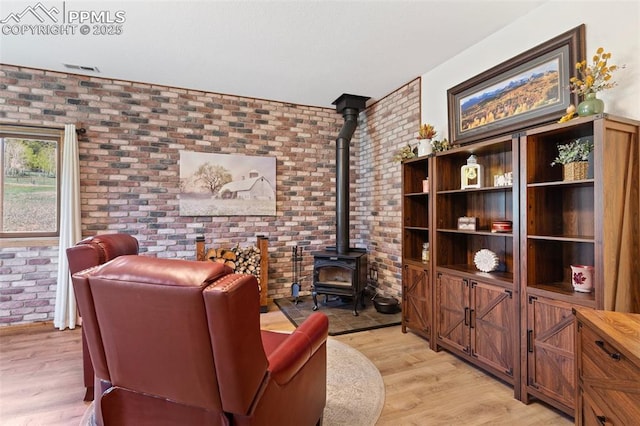 802 Red Eagle Ct, Woodland Park, CO 80863 - living area with brick wall, a wood stove, and light wood-type flooring