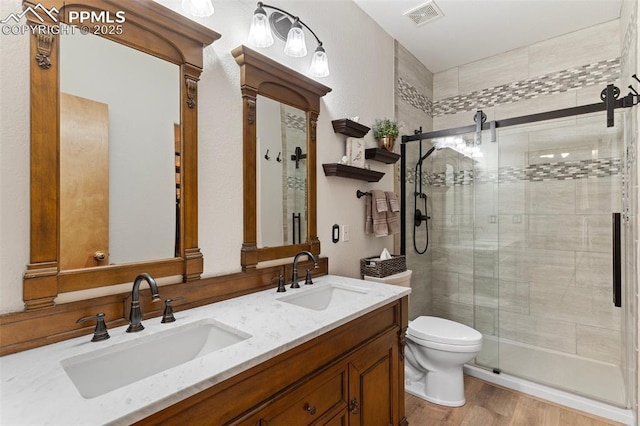 802 Red Eagle Ct, Woodland Park, CO 80863 - bathroom with a stall shower, double vanity, toilet, and wood finished floors