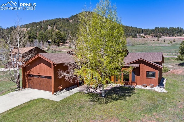 802 Red Eagle Ct, Woodland Park, CO 80863 - view of front of home featuring a shingled roof, a front lawn, concrete driveway, and a wooded view