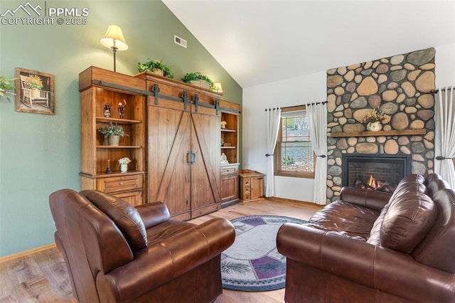802 Red Eagle Ct, Woodland Park, CO 80863 - living area with light wood-style flooring, high vaulted ceiling, a fireplace, and baseboards