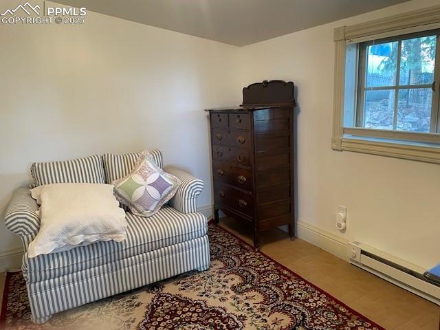 304 N 4th St, Victor, CO 80860 - bedroom with a baseboard heating unit, baseboards, and wood finished floors