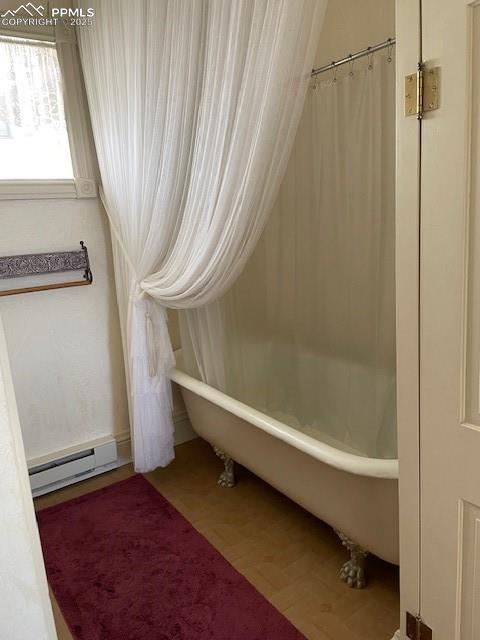 304 N 4th St, Victor, CO 80860 - full bathroom with a baseboard radiator, a freestanding tub, and wood finished floors