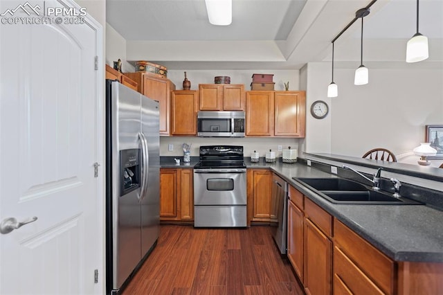 6678 Bethesda Pt Unit C, Colorado Springs, CO 80918 - kitchen with appliances with stainless steel finishes, dark countertops, brown cabinets, dark wood-style floors, and a peninsula