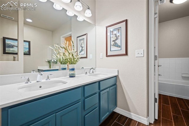 6678 Bethesda Pt Unit C, Colorado Springs, CO 80918 - bathroom featuring wood tiled floors, double vanity, and a tub to relax in