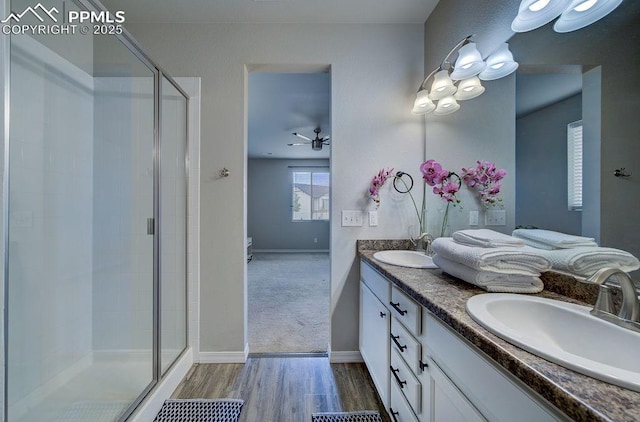 10144 Bluffstone Ct, Peyton, CO 80831 - full bath featuring double vanity, a shower stall, wood finished floors, and baseboards