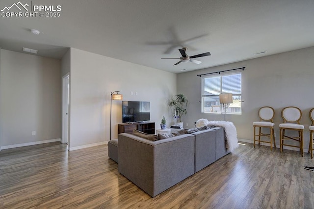 10144 Bluffstone Ct, Peyton, CO 80831 - living area featuring wood finished floors, a ceiling fan, and baseboards