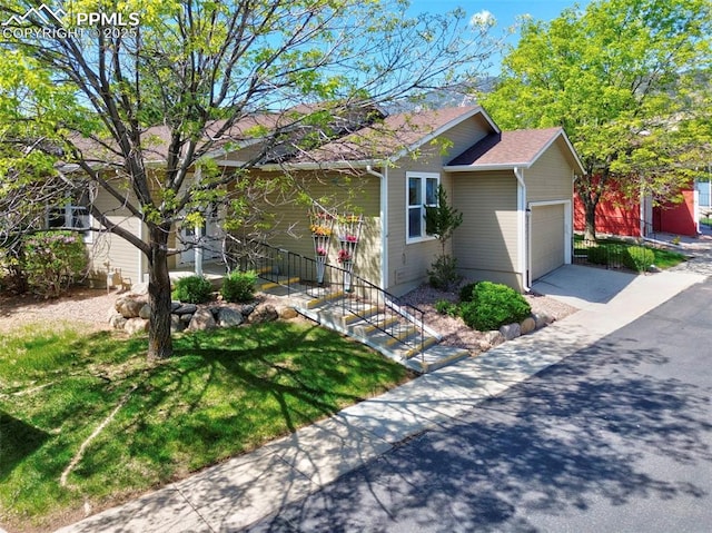 2609 Freedom Hts, Colorado Springs, CO 80904 - view of side of home featuring a garage, concrete driveway, and a lawn