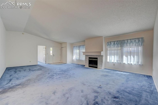 2609 Freedom Hts, Colorado Springs, CO 80904 - unfurnished living room with vaulted ceiling, a tiled fireplace, and carpet floors