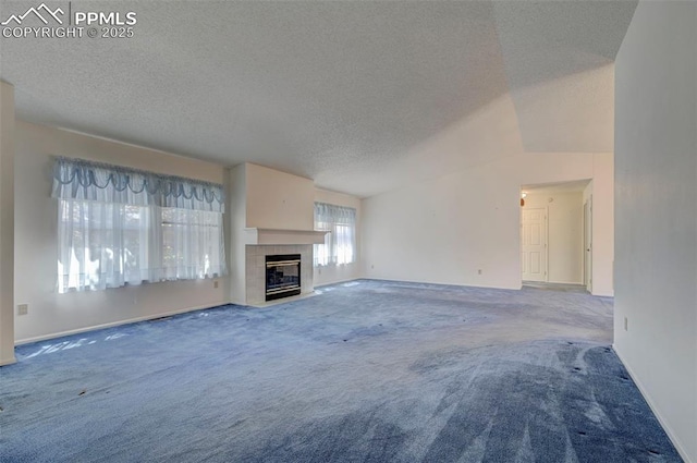 2609 Freedom Hts, Colorado Springs, CO 80904 - unfurnished living room featuring carpet, a textured ceiling, a tiled fireplace, baseboards, and lofted ceiling