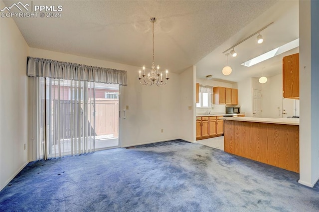 2609 Freedom Hts, Colorado Springs, CO 80904 - kitchen featuring a chandelier, light colored carpet, black microwave, and a textured ceiling