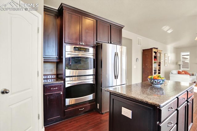 9773 Beryl Dr, Peyton, CO 80831 - kitchen with stainless steel appliances, dark wood-type flooring, open floor plan, a center island, and stone countertops