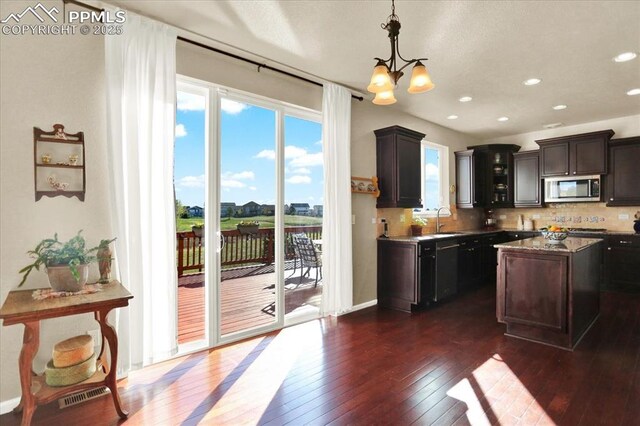 9773 Beryl Dr, Peyton, CO 80831 - kitchen featuring stainless steel microwave, a sink, a chandelier, dark wood-type flooring, and healthy amount of natural light