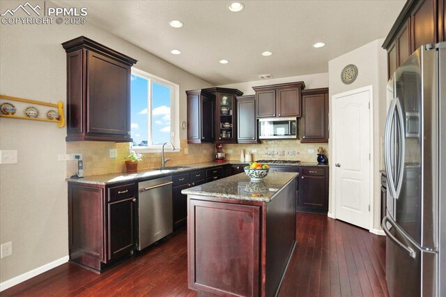 9773 Beryl Dr, Peyton, CO 80831 - kitchen with stainless steel appliances, a sink, stone counters, dark wood finished floors, and backsplash