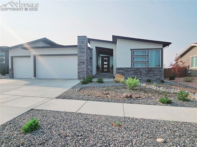 4017 Notch Trl, Colorado Springs, CO 80924 - view of front of house featuring stone siding, a garage, concrete driveway, and stucco siding