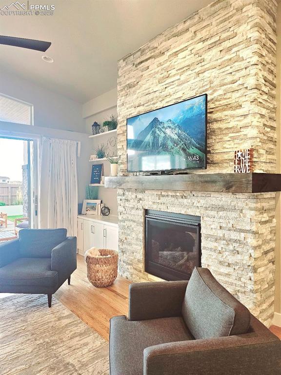 4017 Notch Trl, Colorado Springs, CO 80924 - living area featuring wood finished floors and a stone fireplace