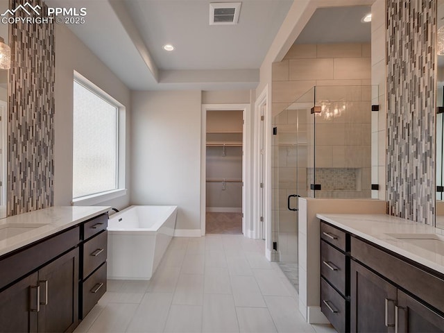 4017 Notch Trl, Colorado Springs, CO 80924 - bathroom with a shower stall, two vanities, a freestanding tub, baseboards, and tile patterned flooring