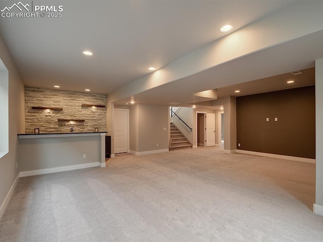 4017 Notch Trl, Colorado Springs, CO 80924 - unfurnished living room featuring stairs, light carpet, bar with sink, baseboards, and recessed lighting
