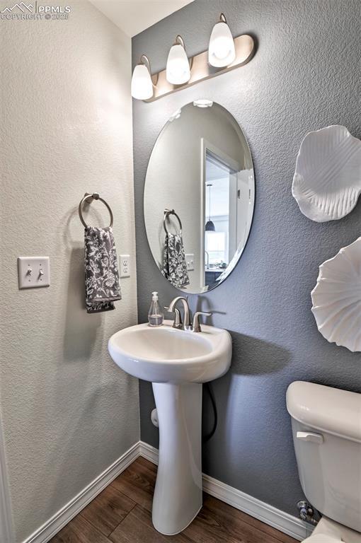 10811 Raylan Way, Falcon, CO 80831 - bathroom featuring wood finished floors, baseboards, and toilet