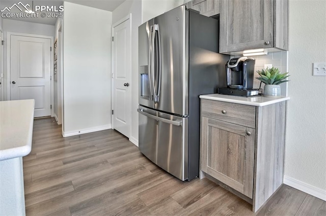 10811 Raylan Way, Falcon, CO 80831 - kitchen featuring stainless steel fridge with ice dispenser, light wood-type flooring, light countertops, and baseboards