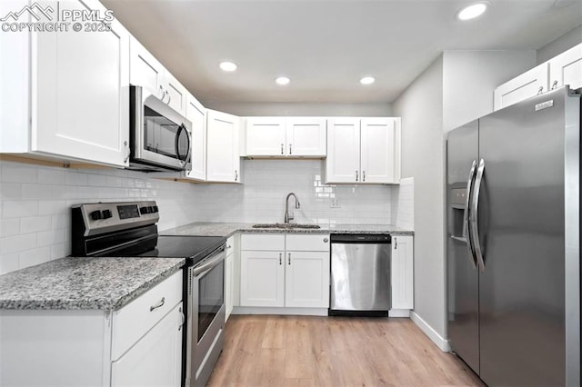 1210 Westend Ave, Colorado Springs, CO 80904 - kitchen with appliances with stainless steel finishes, a sink, light wood finished floors, white cabinetry, and recessed lighting
