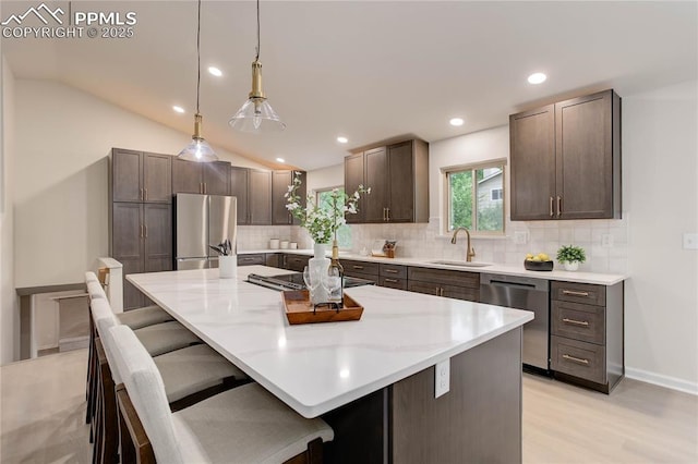 5208 Pinon Valley Rd, Colorado Springs, CO 80919 - kitchen featuring stainless steel appliances, a sink, decorative backsplash, a breakfast bar area, and a center island
