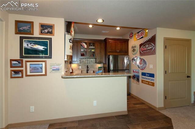 797 Forest View Way, Monument, CO 80132 - kitchen featuring a peninsula, recessed lighting, tasteful backsplash, baseboards, and freestanding refrigerator