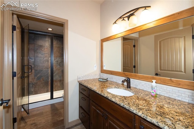 797 Forest View Way, Monument, CO 80132 - bathroom featuring vanity, decorative backsplash, a stall shower, recessed lighting, and wood finished floors