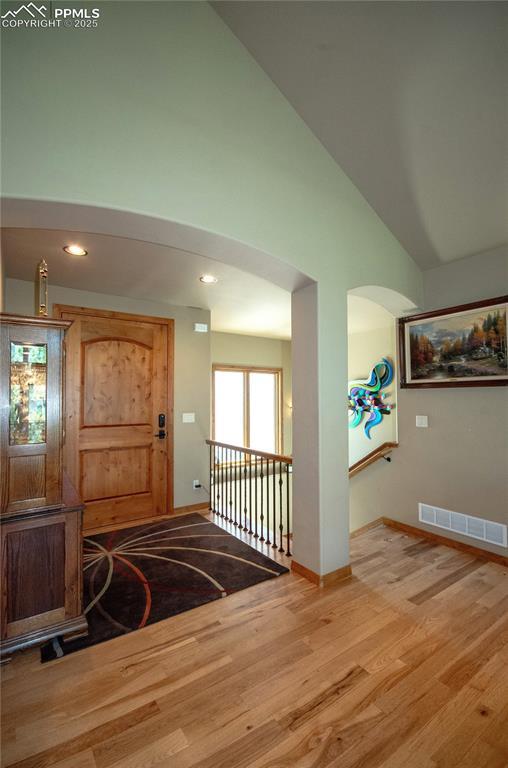 797 Forest View Way, Monument, CO 80132 - entryway featuring baseboards, wood finished floors, arched walkways, high vaulted ceiling, and recessed lighting