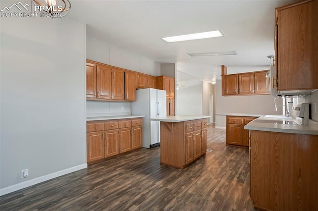 20150 Enoch Rd, Colorado Springs, CO 80930 - kitchen featuring white appliances, a kitchen island, brown cabinets, dark wood-type flooring, and baseboards