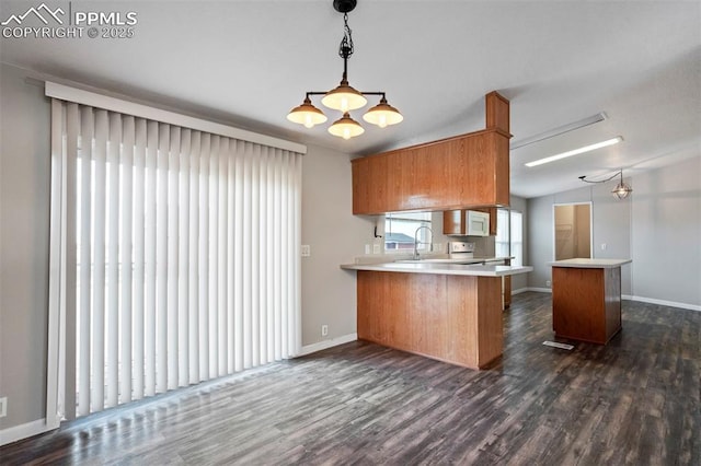 20150 Enoch Rd, Colorado Springs, CO 80930 - kitchen with white microwave, a peninsula, dark wood-type flooring, brown cabinets, and baseboards