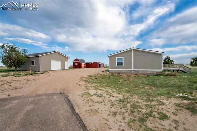 20150 Enoch Rd, Colorado Springs, CO 80930 - view of side of property with an outbuilding, driveway, and a deck