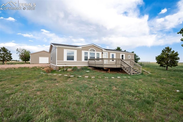 20150 Enoch Rd, Colorado Springs, CO 80930 - back of property with a wooden deck, a lawn, a garage, driveway, and an outbuilding