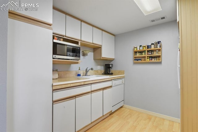 1018 Fontmore Rd Unit D, Colorado Springs, CO 80904 - kitchen with dishwasher, stainless steel microwave, a sink, light wood-style floors, and light countertops