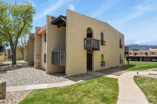 1018 Fontmore Rd Unit D, Colorado Springs, CO 80904 - view of side of property with a balcony, stucco siding, a mountain view, and a yard