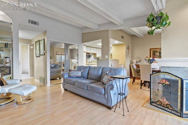 1018 Fontmore Rd Unit D, Colorado Springs, CO 80904 - living room with beam ceiling, light wood-style flooring, baseboards, and a textured ceiling