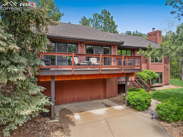 720 Popes Valley Dr, Colorado Springs, CO 80919 - back of property featuring a chimney, driveway, a garage, and a wooden deck
