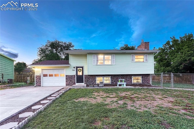 7108 Chippewa Rd, Colorado Springs, CO 80915 - tri-level home featuring a garage, a chimney, and driveway