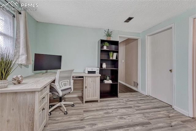 7108 Chippewa Rd, Colorado Springs, CO 80915 - home office with light wood-type flooring and a textured ceiling