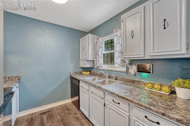 7108 Chippewa Rd, Colorado Springs, CO 80915 - kitchen featuring dishwasher, range, dark wood-type flooring, white cabinetry, and a textured wall