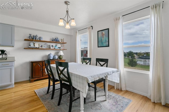 7711 Menagerie Ln, Colorado Springs, CO 80923 - dining space with light wood-style floors, baseboards, and a chandelier