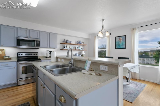 7711 Menagerie Ln, Colorado Springs, CO 80923 - kitchen with stainless steel appliances, a sink, plenty of natural light, and light countertops
