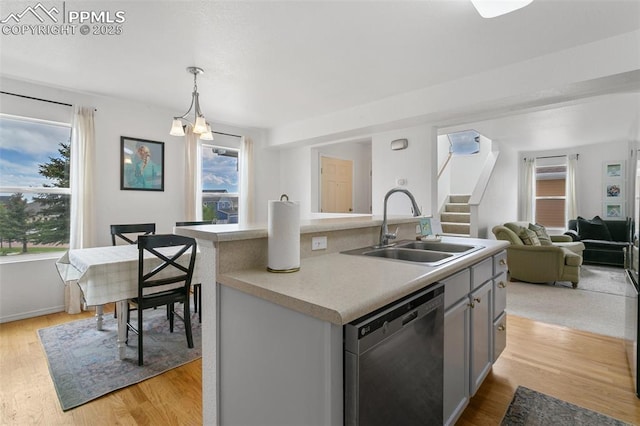 7711 Menagerie Ln, Colorado Springs, CO 80923 - kitchen with dishwashing machine, a sink, open floor plan, light countertops, and pendant lighting