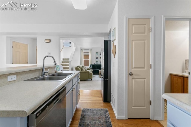 7711 Menagerie Ln, Colorado Springs, CO 80923 - kitchen with appliances with stainless steel finishes, a sink, light countertops, light wood finished floors, and open floor plan