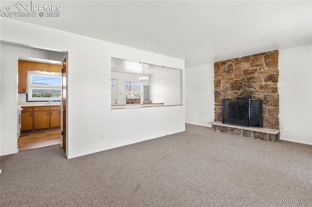 3510 Jon St, Colorado Springs, CO 80907 - unfurnished living room with carpet flooring, a stone fireplace, and a chandelier