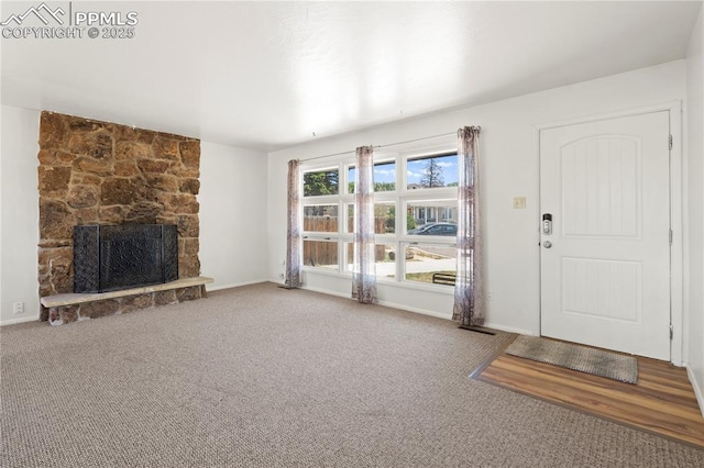 3510 Jon St, Colorado Springs, CO 80907 - unfurnished living room featuring carpet floors, a stone fireplace, and baseboards