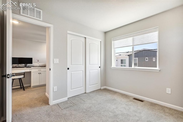 10671 Larimar Pt, Colorado Springs, CO 80905 - unfurnished bedroom featuring light carpet, an office area, a closet, and baseboards